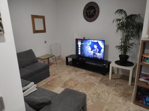 a living room with a couch and a flat screen tv at maison luxe cléo aeroport tillé 4 personnes in Tillé