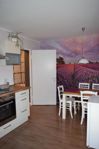 eine Küche mit einem Tisch und einem Feld mit lila Blumen in der Unterkunft Ferienwohnung Wörrstadt in Wörrstadt
