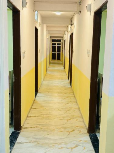 a long hallway with yellow and green walls at HOTEL G9 in Maheshwar