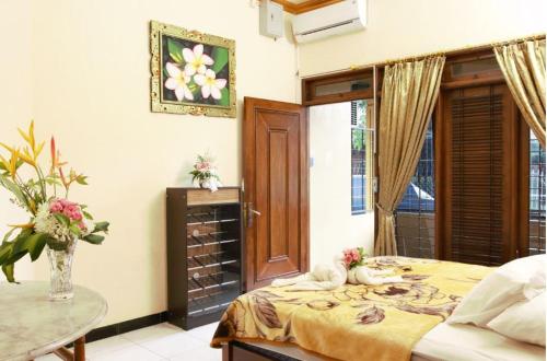 - une chambre avec un lit, une table et une fenêtre dans l'établissement Joyful Home 2, à Yogyakarta