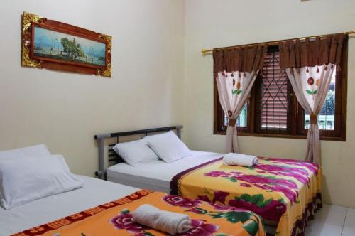 - une chambre avec 2 lits et une fenêtre dans l'établissement Joyful Home 2, à Yogyakarta