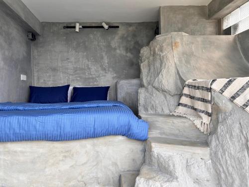 een slaapkamer met een bed met blauwe kussens bij Three Creeks Matale in Matale