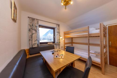 ein Wohnzimmer mit einem Tisch und einem Etagenbett in der Unterkunft Ferienhaus am See in Zell am See