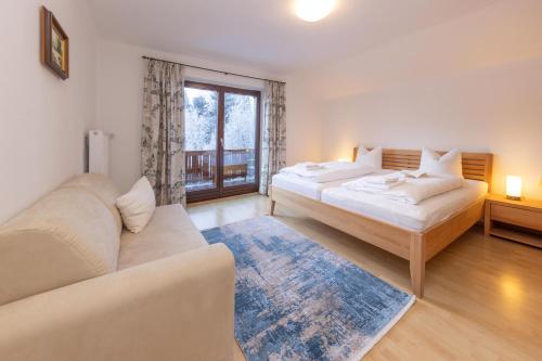 sala de estar con 2 camas y sofá en Ferienhaus am See en Zell am See