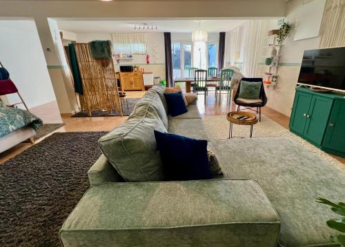 uma sala de estar com um sofá verde e uma mesa em Nazare Oasis Suites and Retreats em Nazaré