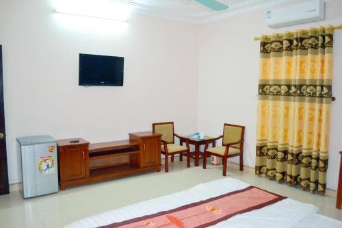 Cette chambre comprend un bureau, une table et des chaises. dans l'établissement Khách sạn Anh Đào, à Lạng Sơn