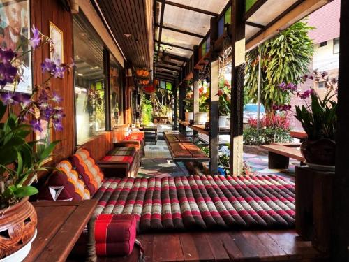 a row of benches on a porch with plants at Panda House Chiang Mai in Chiang Mai