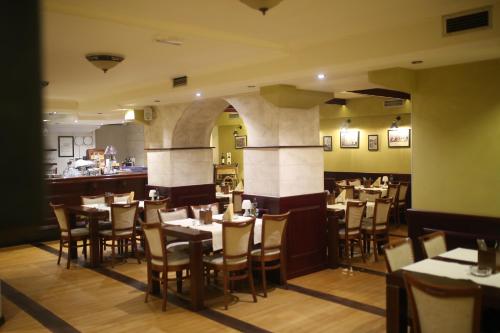 un ristorante con tavoli e sedie e un bar di Motel Royal a Tuzla