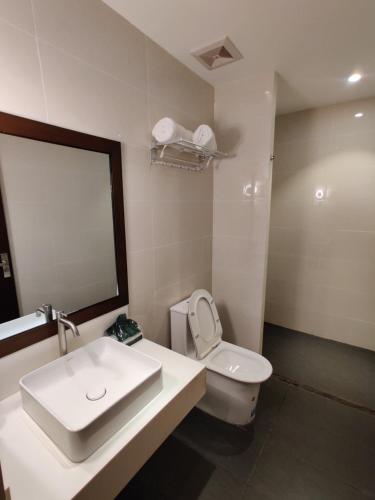 W łazience znajduje się umywalka, toaleta i lustro. w obiekcie Altori Park Hotel w mieście General Santos