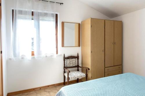 a bedroom with a bed and a chair and a cabinet at Trilocale con A/C a Marcelli - M035 in Marcelli