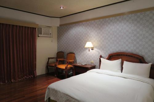 Un pat sau paturi într-o cameră la Champagne Hotel