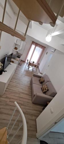 a living room with a couch and a table at SUITE BLANC APARTMENTS - Monolocali indipendenti con cucina e bagno privato - Check-in e check-out con codice in autonomia h24 - Terrazza in comune NECESSARIO AVERE WATHSAPP O APP DI MESSAGGISTICA ISTANTANEA PER FOTO E VIDEO in Guspini