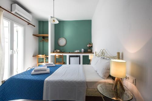 een slaapkamer met een bed met een blauwe muur bij V-rooms in Milos Cyclades in Pollonia