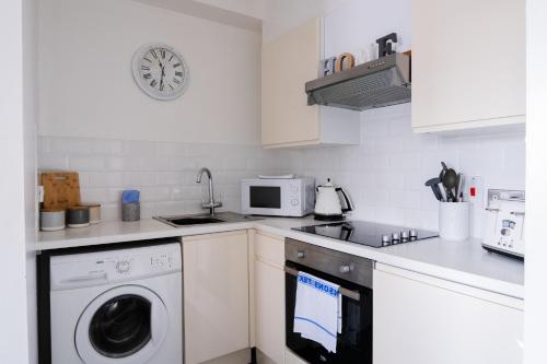 a kitchen with a washing machine and a microwave at Luxury one bed Apartment in Carterton