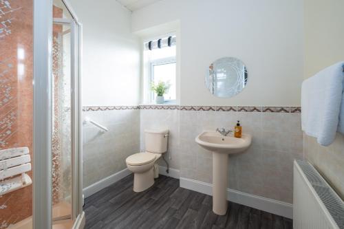 a bathroom with a toilet and a sink at The Beach and Golfers Cottage in Monifieth