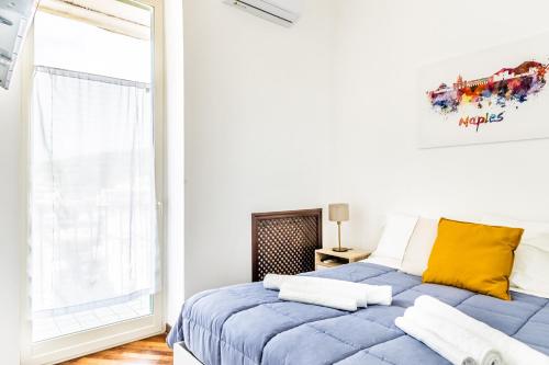 a bedroom with a blue bed and a window at Bacoli Sveva Luxury House - Terrace & Design in Bacoli