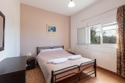 a bedroom with a bed and a window at Domas Blue Studio Villa With Private Pool and Panoramic View in Loutra