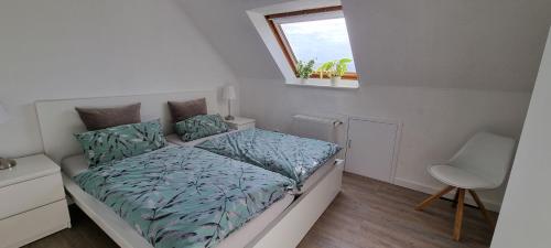 um pequeno quarto com uma cama e uma janela em Ferienwohnung Barntrup Lippe em Barntrup