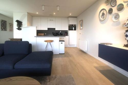 a living room with a couch and a kitchen at Zeewaarts in Cadzand