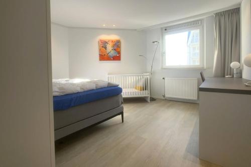 a bedroom with a bed and a window at Zeewaarts in Cadzand