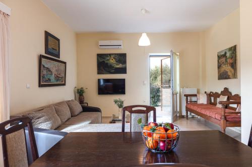 a living room with a table with a bowl of fruit on it at Domas Blue Studio Villa With Private Pool and Panoramic View in Loutra