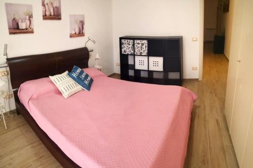 um quarto com uma cama com um cobertor rosa em casa Mari, 250 mt dalle spiagge em Diano Marina