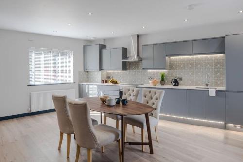 a kitchen with a wooden table and chairs in a kitchen at Barley View Luxury Home in Bristol