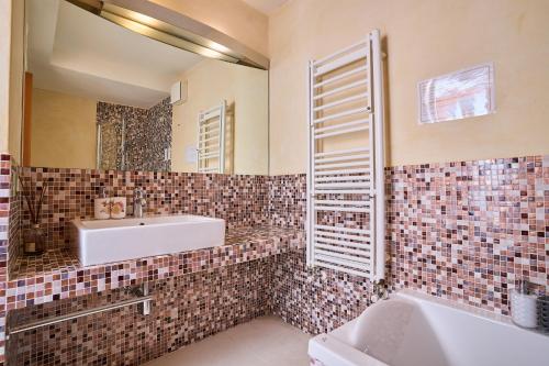 uma casa de banho com um lavatório, uma banheira e um espelho. em [Villa Privata] Vista Mare - in Portovenere em Fezzano