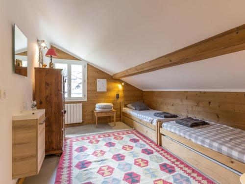 une chambre avec deux lits et un tapis dans l'établissement Chalet cosy au cœur du village, proche pistes et activités, avec cheminée et WIFI - FR-1-304-6, à La Clusaz