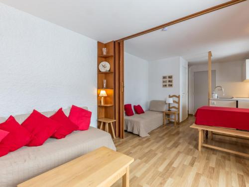 Habitación con 2 camas y almohadas rojas. en Appartement La Clusaz, 2 pièces, 4 personnes - FR-1-304-4, en La Clusaz