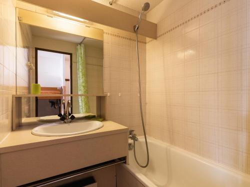 a bathroom with a sink and a tub and a mirror at Appartement La Clusaz, 2 pièces, 5 personnes - FR-1-304-33 in La Clusaz