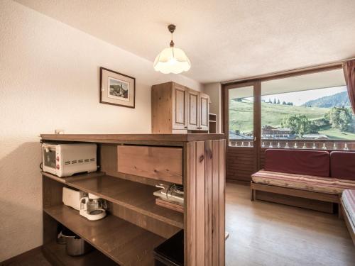 a room with a counter with a microwave and a window at Studio La Clusaz, 1 pièce, 4 personnes - FR-1-304-30 in La Clusaz
