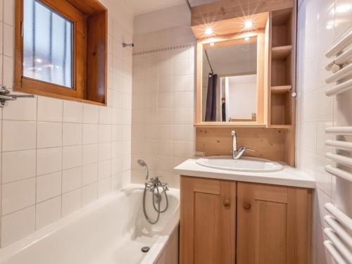 a bathroom with a sink and a tub and a mirror at Studio La Clusaz, 1 pièce, 4 personnes - FR-1-304-30 in La Clusaz