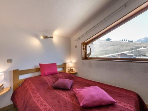 ラ・クリュサにあるAppartement La Clusaz, 4 pièces, 6 personnes - FR-1-304-35のベッドルーム1室(ピンクの枕が付くベッド1台、窓付)