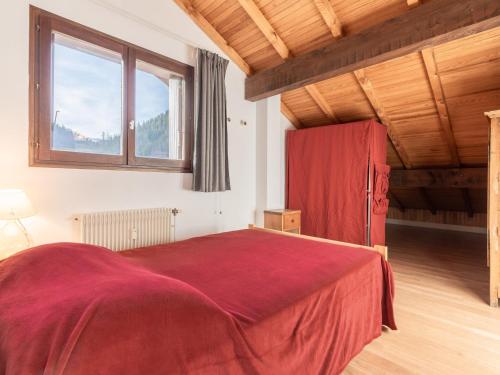 ラ・クリュサにあるAppartement La Clusaz, 4 pièces, 8 personnes - FR-1-304-3の赤いベッドと赤い冷蔵庫付きのベッドルーム1室が備わります。