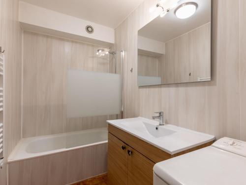 a bathroom with a sink and a tub and a mirror at Appartement La Clusaz, 4 pièces, 8 personnes - FR-1-304-3 in La Clusaz