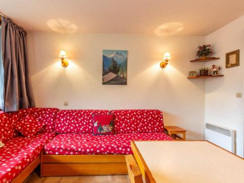 a living room with a red couch and a table at Appartement La Clusaz, 2 pièces, 5 personnes - FR-1-304-38 in La Clusaz