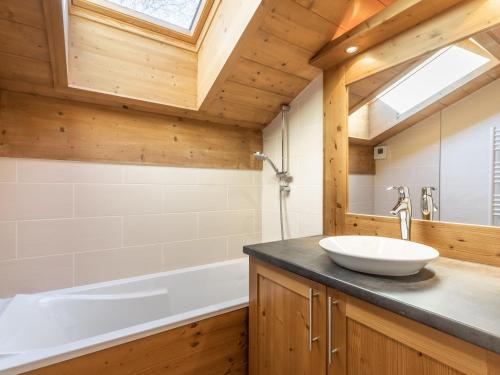 une salle de bain avec un lavabo et une baignoire dans l'établissement Appartement cosy 3 pièces avec wifi, jusqu'à 8 personnes - FR-1-304-237, à La Clusaz