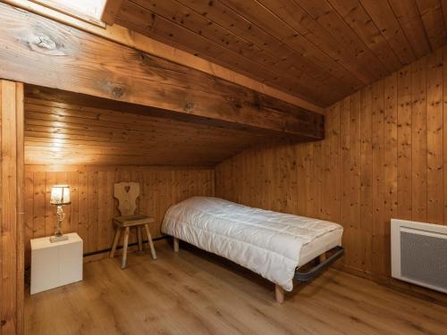 een slaapkamer met een bed in een houten kamer bij Appartement La Clusaz, 3 pièces, 6 personnes - FR-1-304-259 in La Clusaz