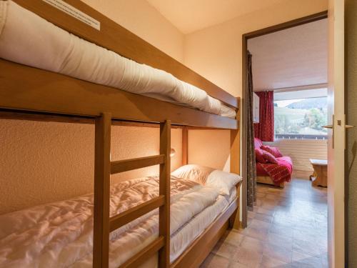 two bunk beds in a room with a mirror at Studio La Clusaz, 1 pièce, 3 personnes - FR-1-304-264 in La Clusaz