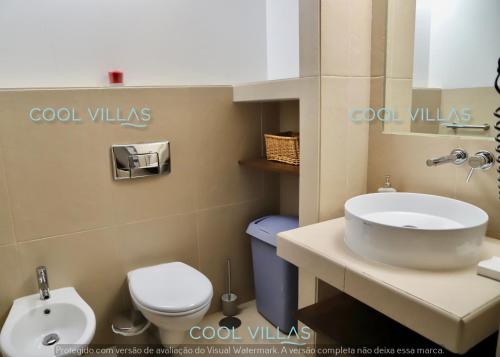 een badkamer met een witte wastafel en een toilet bij Casa 3 Papoilas in Albufeira