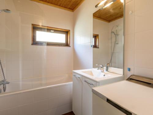 a white bathroom with a sink and a bath tub at Appartement La Clusaz, 3 pièces, 6 personnes - FR-1-304-151 in La Clusaz