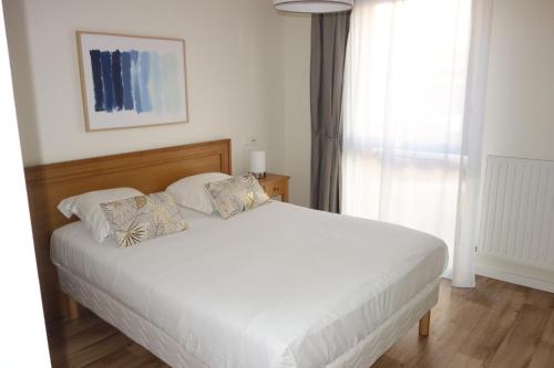 a bedroom with a large white bed and a window at DOMITYS - Le Fil de Soie in Calais