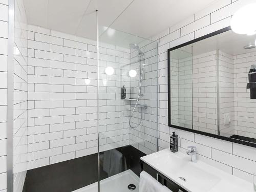 baño blanco con ducha y lavamanos en Hotel ibis Bragança, en Bragança