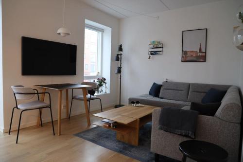 a living room with a couch and a table at Modern apartment in Aarhus with free parking in Risskov