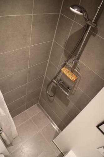 a bathroom with a shower with a tiled wall at Modern apartment in Aarhus with free parking in Risskov