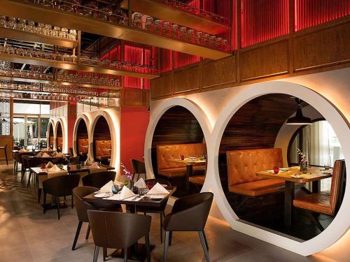 إيبيس وان سنترال - مركز دبي التجاري العالمي في دبي: مطعم به طاولات وكراسي وجدران حمراء