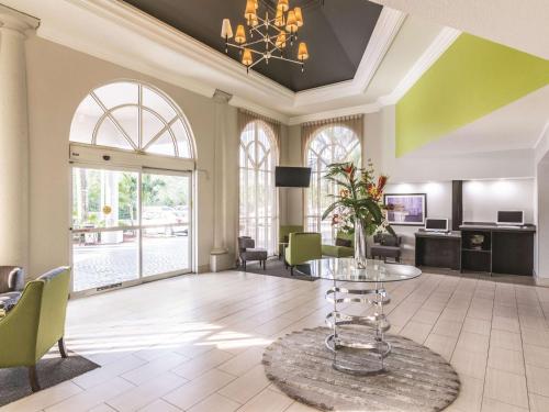 a living room with a table and chairs at La Quinta Inn by Wyndham Jupiter in Jupiter