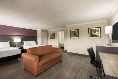 サンアントニオにあるLa Quinta Inn by Wyndham San Antonio Lacklandのベッドとソファ付きのホテルルーム