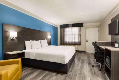 a hotel room with a bed and a desk at La Quinta Inn by Wyndham San Antonio I-35 N at Toepperwein in San Antonio
